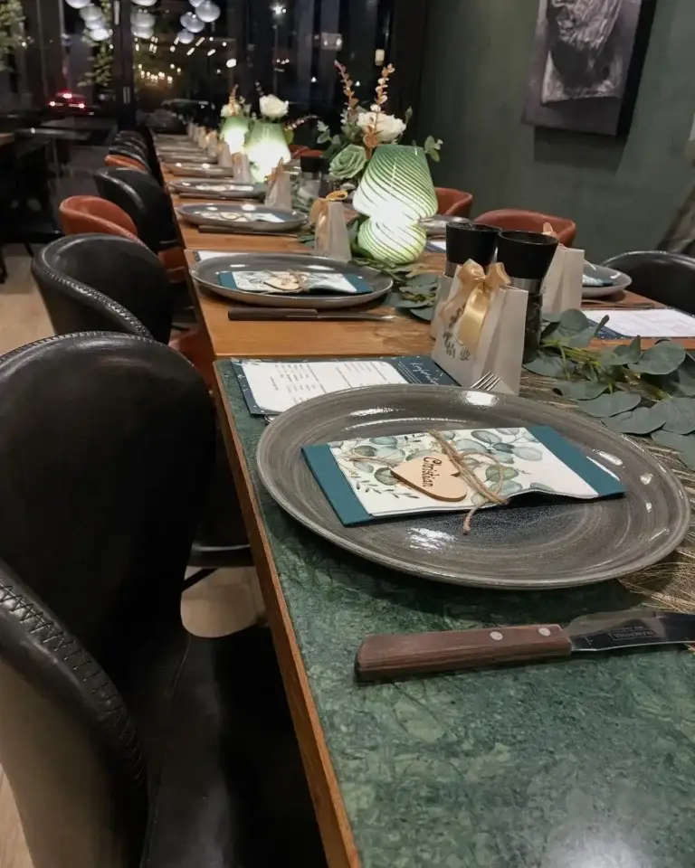 Festligt dækket bord i selskabslokalet hos Restaurant Cooks med menukort og gaveposer